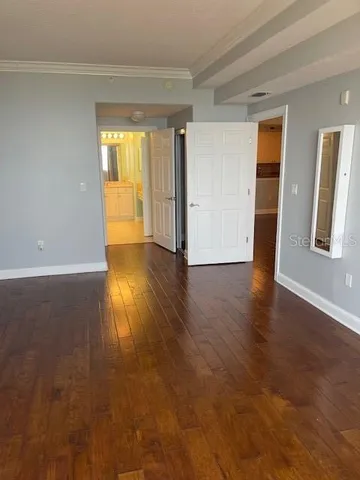 an empty room with wooden floor and closet area