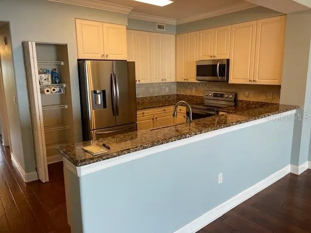 a kitchen with stainless steel appliances granite countertop a refrigerator and a stove top oven