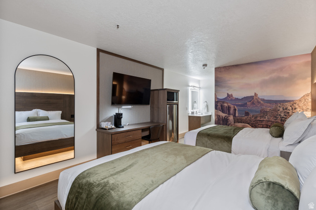 245 Red Cliffs Drive, Unit 104 St. George, UT 84790 - Photo 15 of 33 Bedroom with a textured ceiling, wood finished floors, and ensuite bathroom