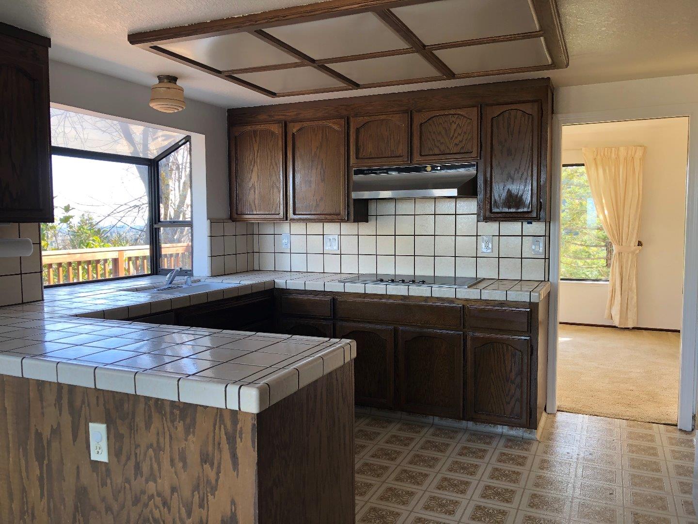 23025 Voss Avenue Cupertino, CA 95014 - Photo 9 of 45 a kitchen with stainless steel appliances kitchen island granite countertop a stove a sink and a microwave
