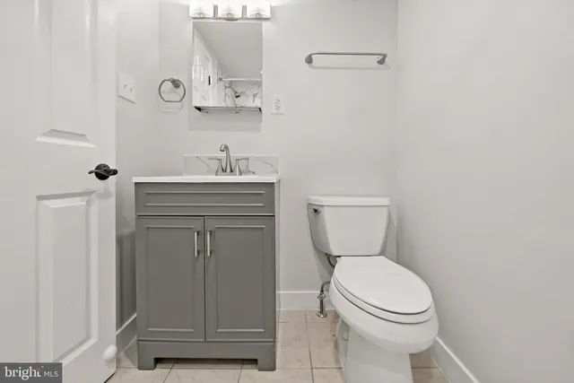 a bathroom with a toilet a sink and mirror
