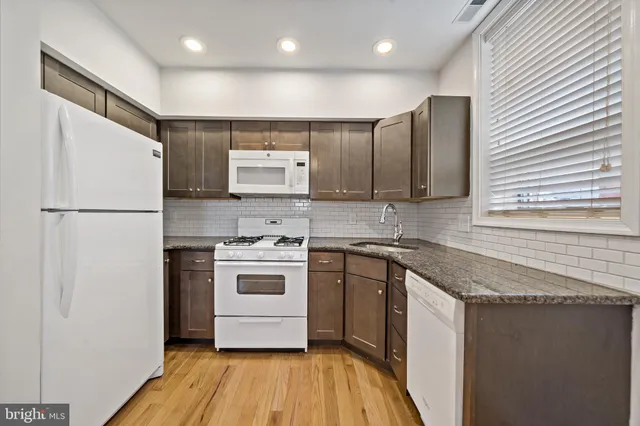 a kitchen with stainless steel appliances granite countertop a refrigerator sink and stove
