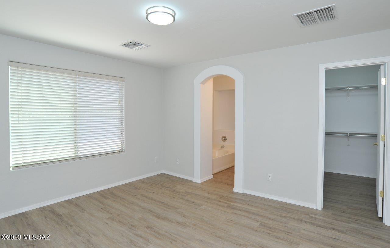 4543 South Valley Road Tucson, AZ 85714 - Photo 20 of 41 an empty room with wooden floor and windows
