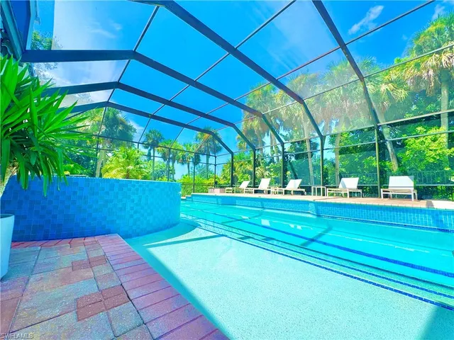 a living room with furniture kitchen view and large windows