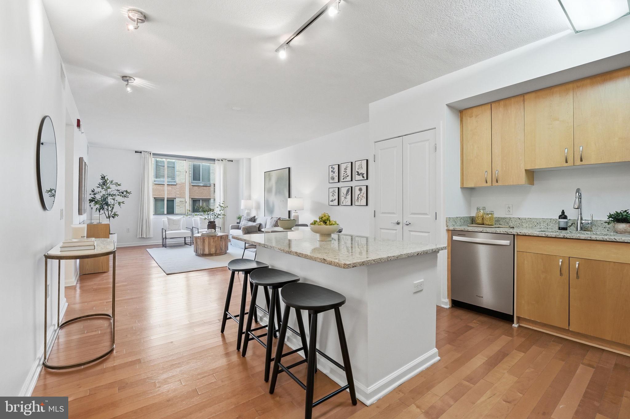 440 L Street Northwest, Unit 809 Washington, DC 20001 - Photo 5 of 50 a kitchen with stainless steel appliances granite countertop a stove top oven a sink dishwasher a dining table and chairs with wooden floor