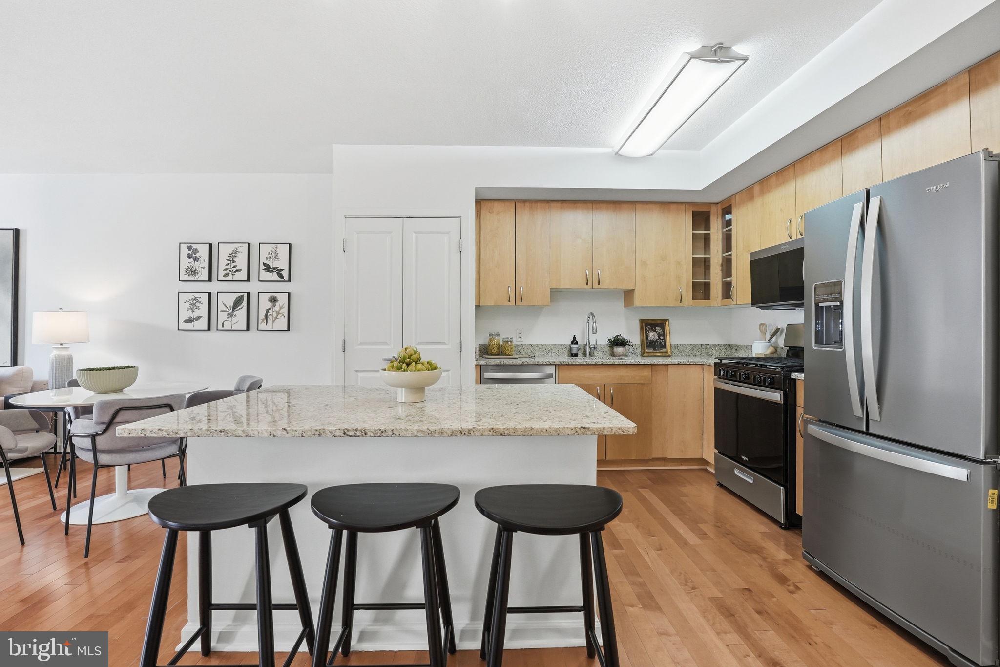 440 L Street Northwest, Unit 809 Washington, DC 20001 - Photo 6 of 50 a kitchen with granite countertop a refrigerator a counter space dining table and chairs
