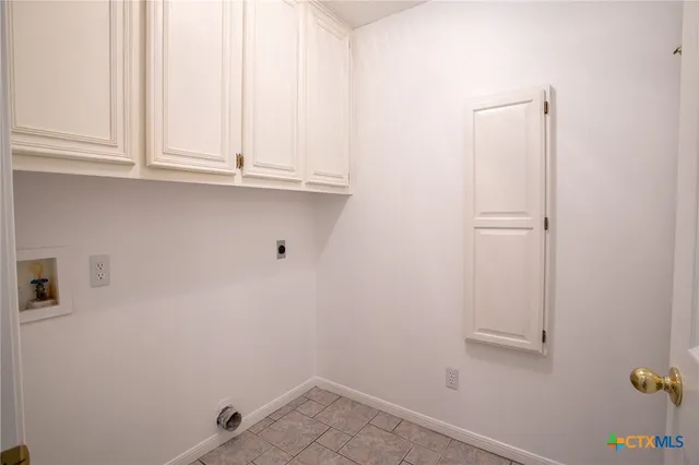 an empty room with wooden floor chandelier fan and windows