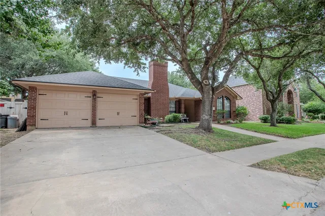 front view of a house with a yard and an trees