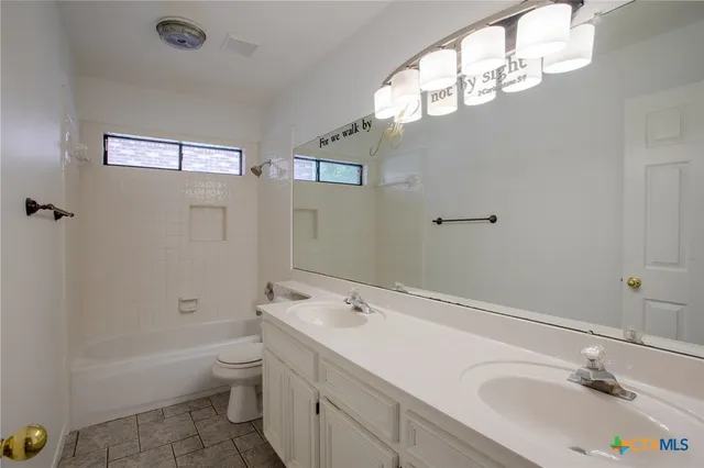 a bathroom with a sink a toilet tub and shower
