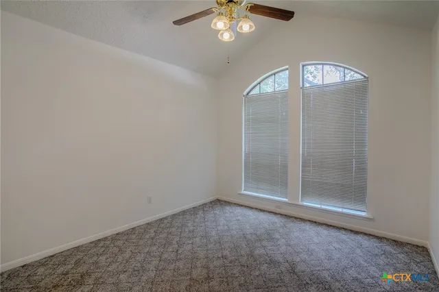 an empty room with wooden floor and hallway
