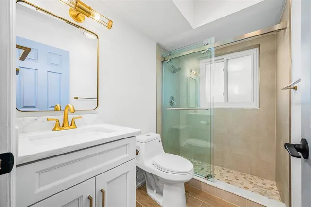 a bathroom with a sink a toilet and shower