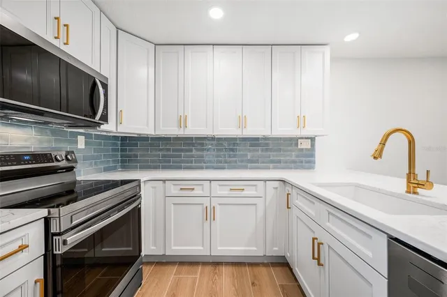 a kitchen with stainless steel appliances granite countertop a sink and a stove