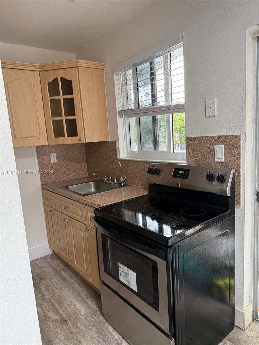 1467 Southwest 3rd Street, Unit 2 Miami, FL 33135 - Photo 14 of 14 a kitchen with granite countertop a stove and a sink