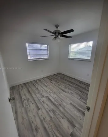 a view of a room with wooden floor and a ceiling fan