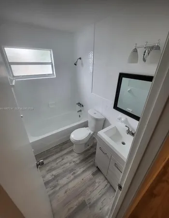 a view of a room with wooden floor and a sink