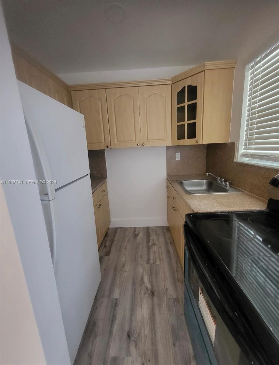 1467 Southwest 3rd Street, Unit 2 Miami, FL 33135 - Photo 10 of 14 a kitchen with a refrigerator sink and cabinets