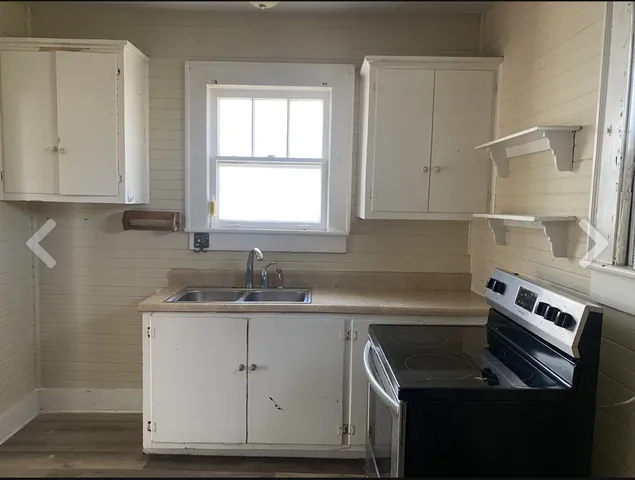 a kitchen with a sink stove and cabinets