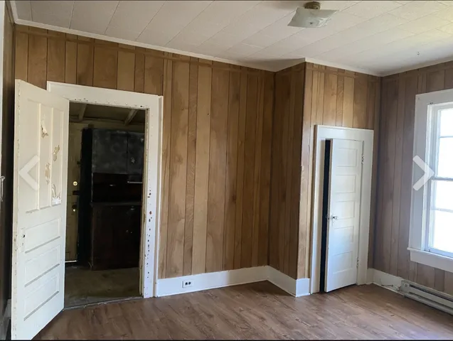 an empty room with a window and closet area
