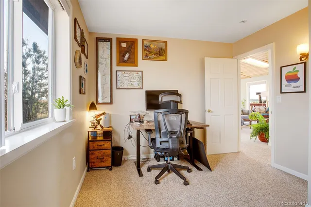 a view of a workspace with furniture and a window