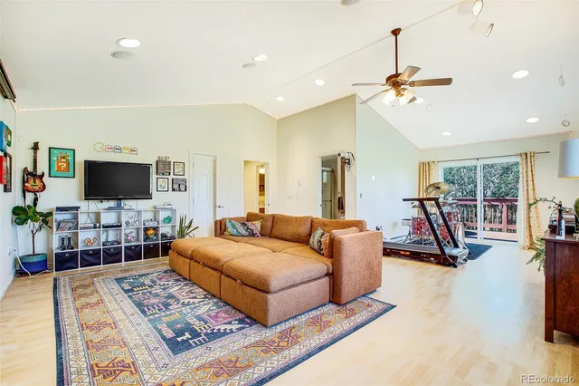a living room with furniture a flat screen tv and a table