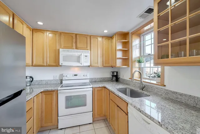 a kitchen with stainless steel appliances granite countertop a sink a stove and cabinets