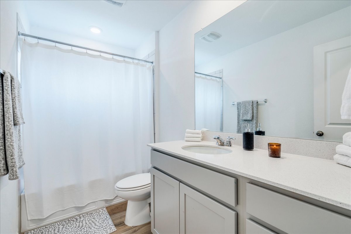 389 Salt Springs Road Kyle, TX 78640 - Photo 20 of 30 A well-appointed bathroom with a single vanity, modern fixtures, and a shower-tub combination.