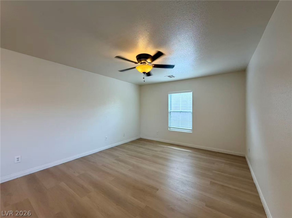 11183 Ranch Valley Street Las Vegas, NV 89179 - Photo 7 of 19 A well-lit bedroom with fresh flooring, providing a comfortable and inviting atmosphere.