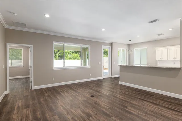 a kitchen with stainless steel appliances kitchen island granite countertop a table chairs and a refrigerator