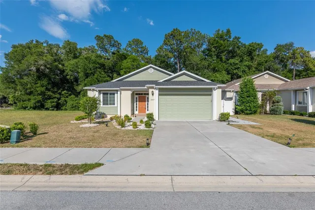 a front view of a house with yard and green space