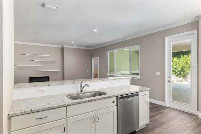 a kitchen with cabinets wooden floor and stainless steel appliances