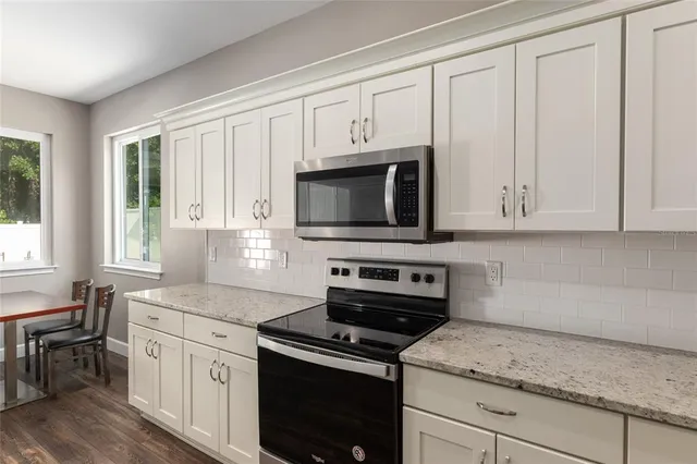 a kitchen with stainless steel appliances a refrigerator sink and microwave