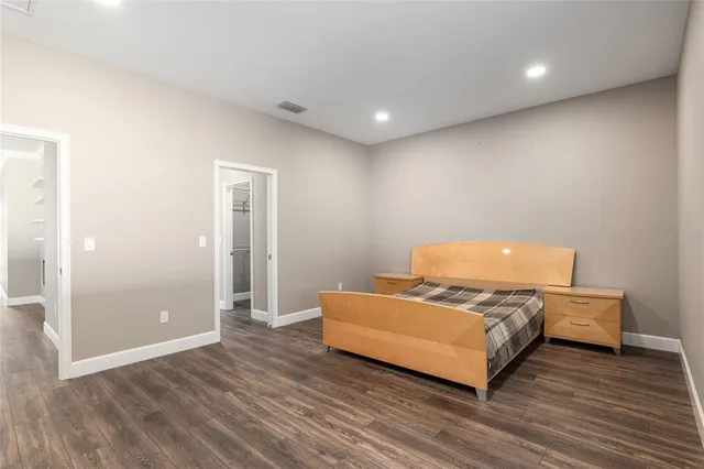 a view of a hallway with wooden floor and closet area