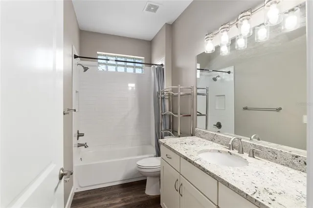 a view of an empty room with wooden floor and closet