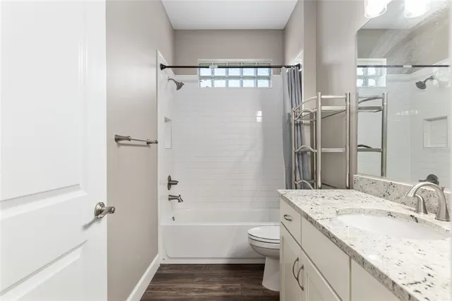 a view of an empty room with wooden floor & closet