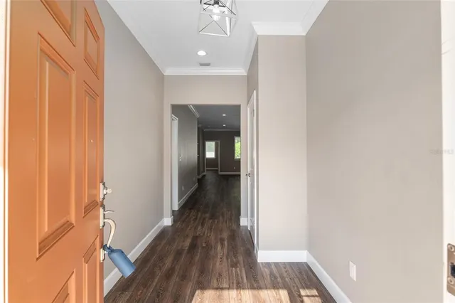 a view of a hallway with wooden floor and a bathroom