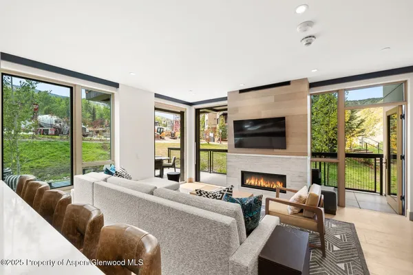 a living room with furniture fireplace and a large window