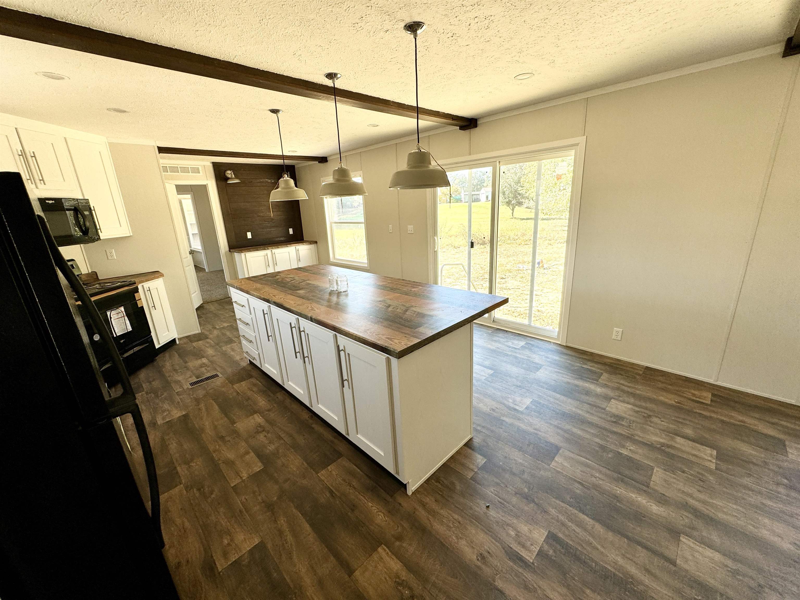 8340 Lightfoot Luckett Road Henning, TN 38041 - Photo 7 of 17 Kitchen with a kitchen island, butcher block counters, hanging light fixtures, white cabinetry, and a textured ceiling