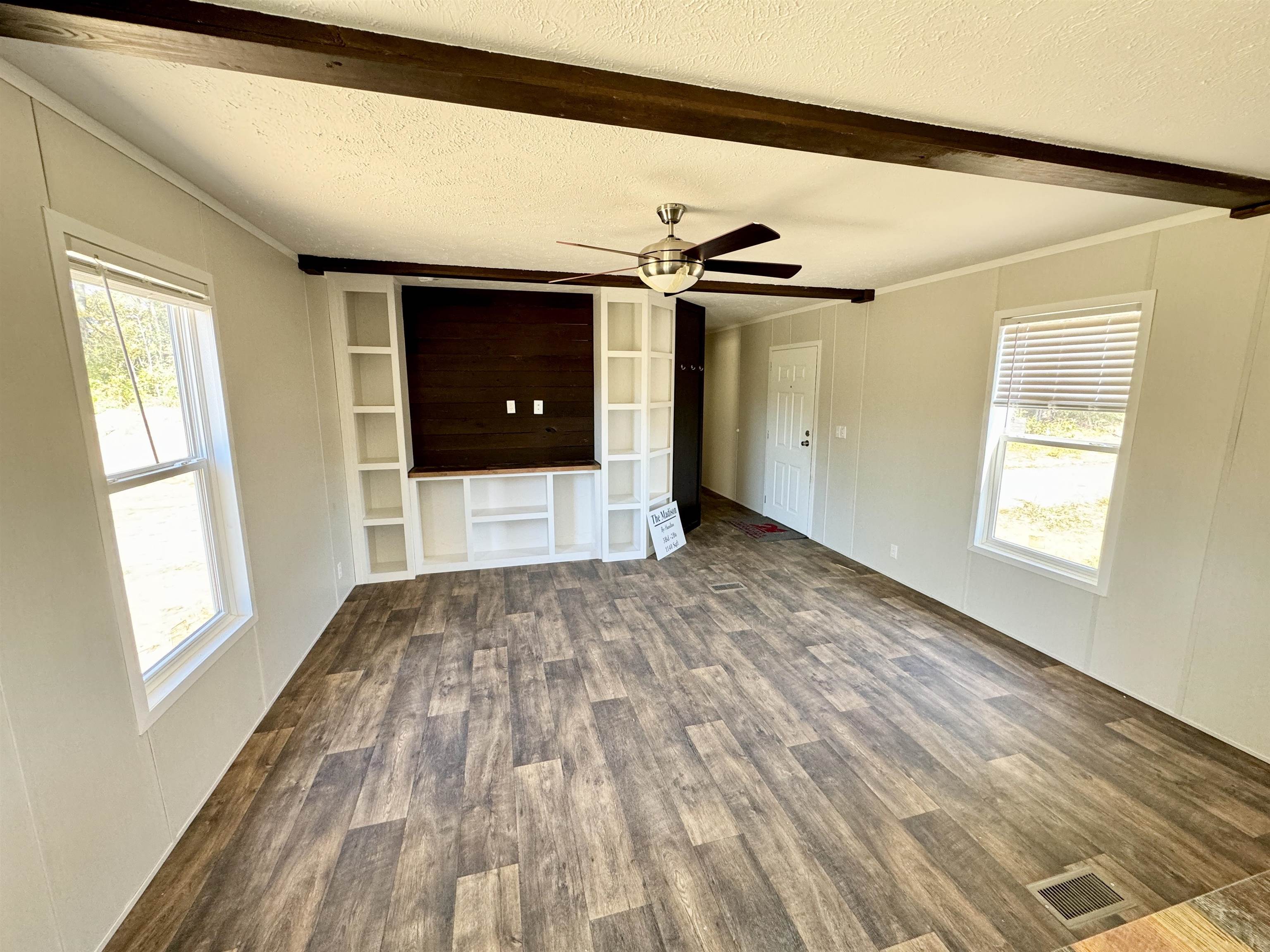 8340 Lightfoot Luckett Road Henning, TN 38041 - Photo 8 of 17 Unfurnished living room with crown molding, ceiling fan, a textured ceiling, and dark hardwood / wood-style flooring