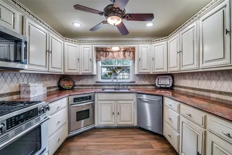 a kitchen with granite countertop cabinets stainless steel appliances and a window