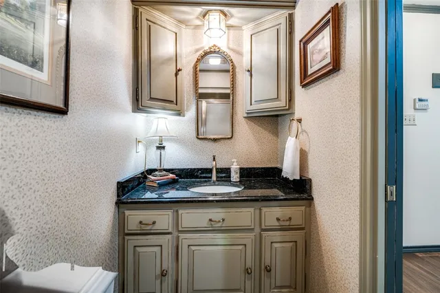 a bathroom with a granite countertop toilet sink and mirror