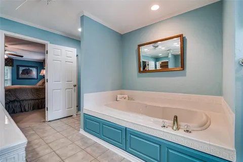 a bathroom with a tub a sink and a mirror