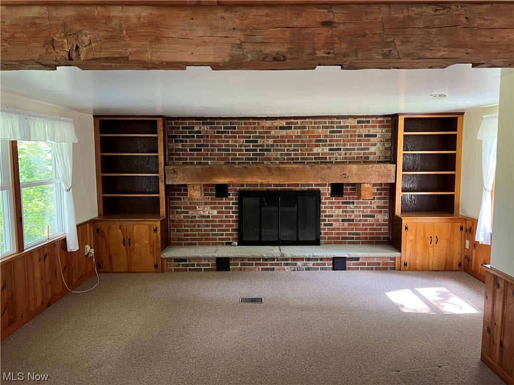 11178 Simcox Road Homerville, OH 44235 - Photo 6 of 17 Carpeted living room with brick wall, built in shelves, and a fireplace