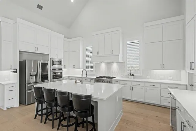 a kitchen with a sink white cabinets and white appliances
