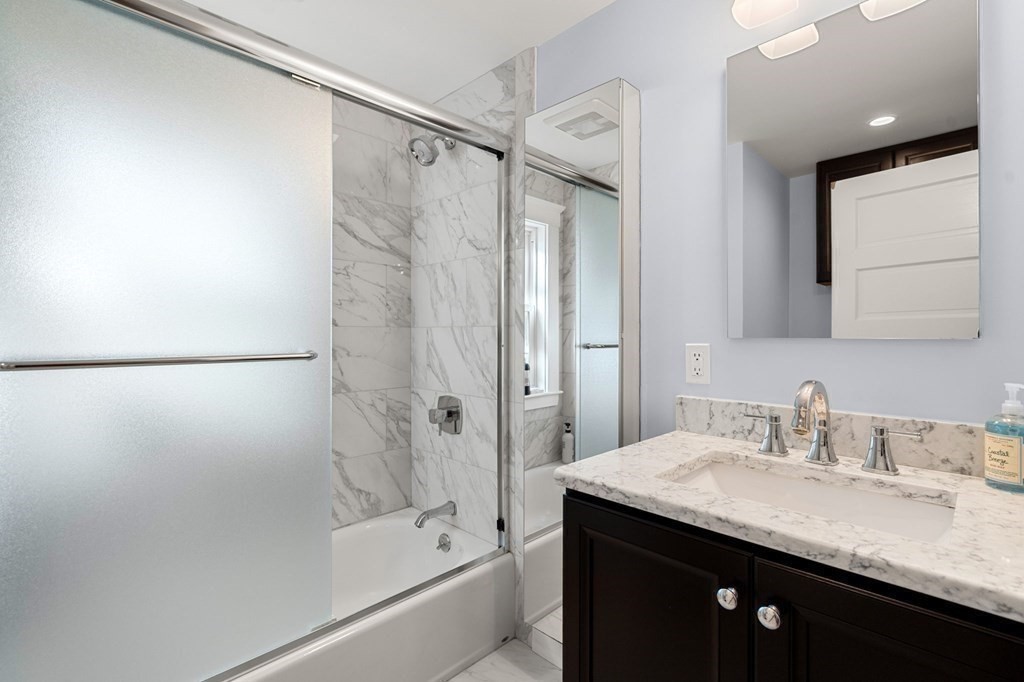 16 Manson Road Needham, MA 02494 - Photo 27 of 34 a bathroom with a granite countertop sink a mirror a shower and a bathtub