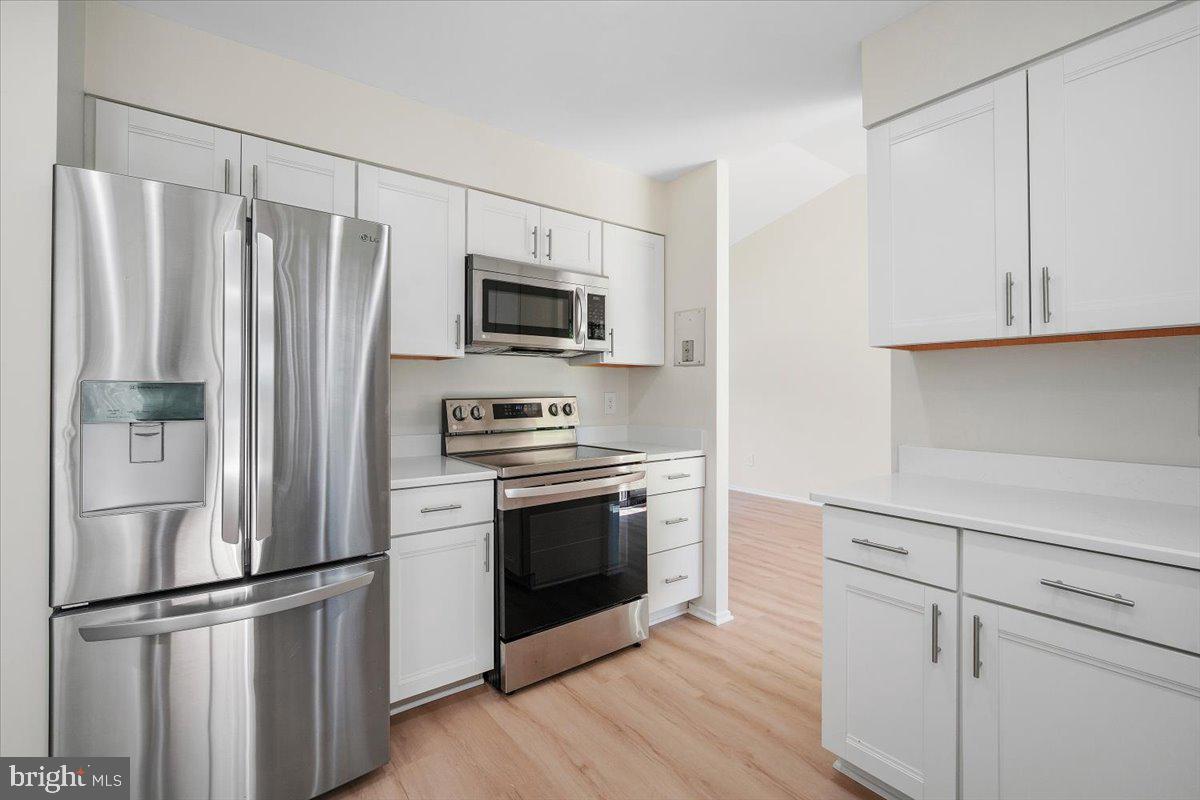 3912 Gelding Lane Olney, MD 20832 - Photo 8 of 62 a kitchen with stainless steel appliances white cabinets and wooden floor