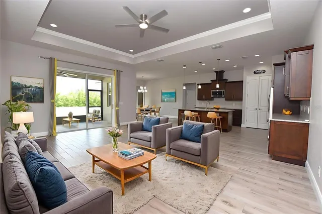 a living room with furniture kitchen view and a window