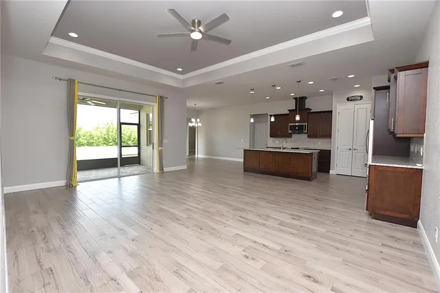 a large kitchen with a wooden floor and stainless steel appliances