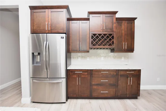 a kitchen with stainless steel appliances granite countertop a refrigerator and a cabinets