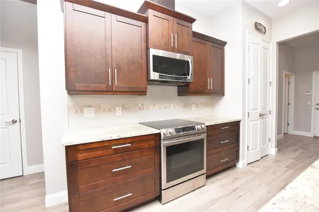 a kitchen with stainless steel appliances granite countertop a stove and a microwave