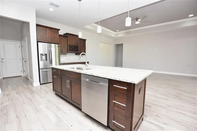 a kitchen with stainless steel appliances a sink cabinets and wooden floor